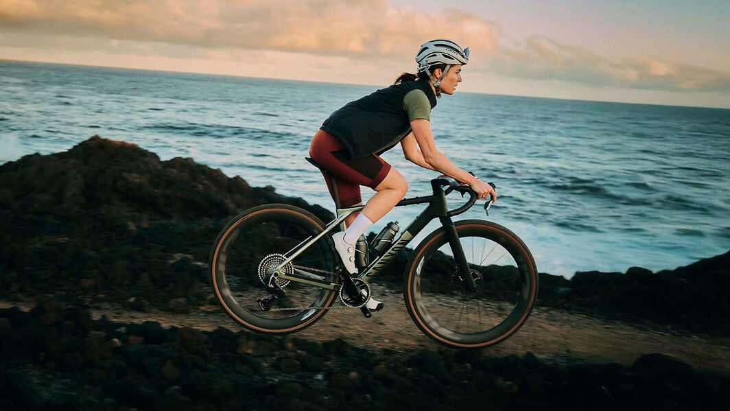 Das Canyon Grizl Gravel Bike mit Bikepacking-Setup inklusive Rahmentasche und zwei Trinkflaschen, hier auf einem staubigen Trail mit DT Swiss Laufrädern.